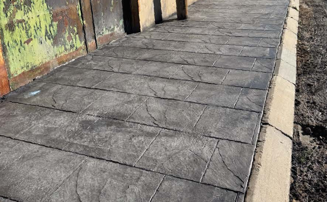 Acera con hormigón impreso color gris